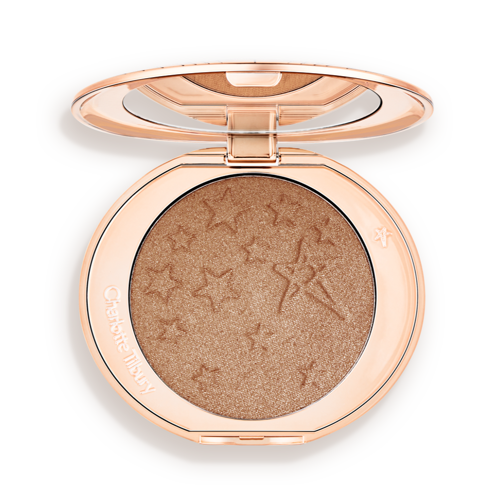An open highlighter powder compact with a mirrored lid, in a shimmery bronze-gold shade. 