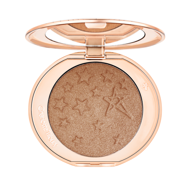 An open highlighter powder compact with a mirrored lid, in a shimmery bronze-gold shade. 