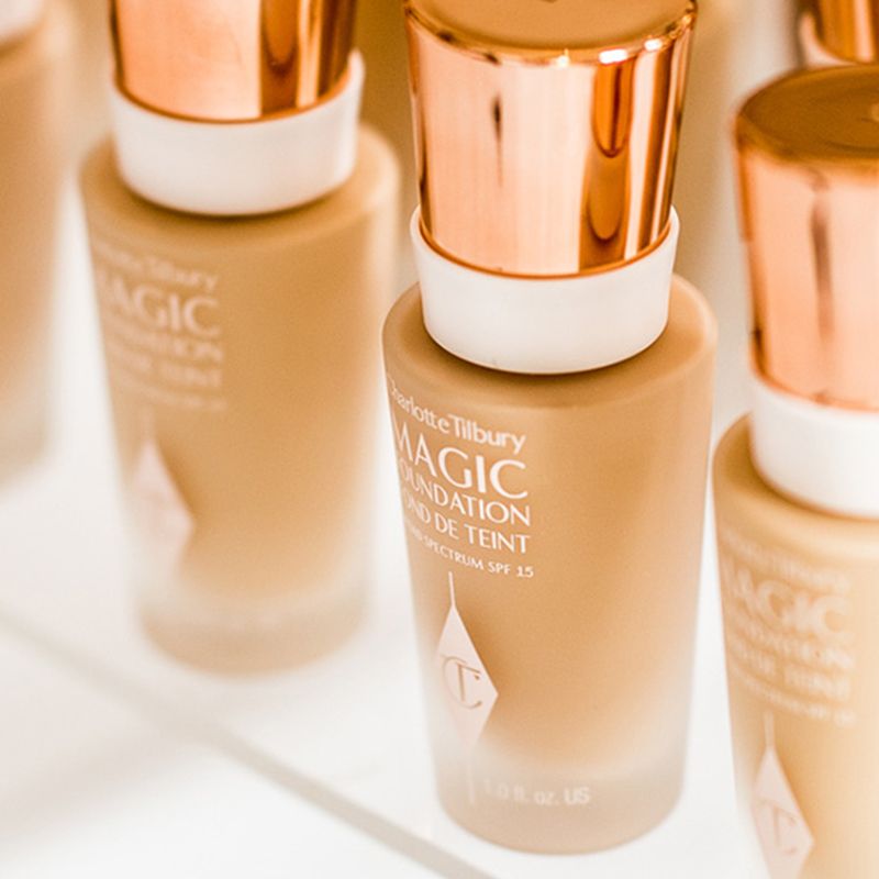 A collection of foundations in frosted glass bottles with rose-gold and white-coloured lids. 