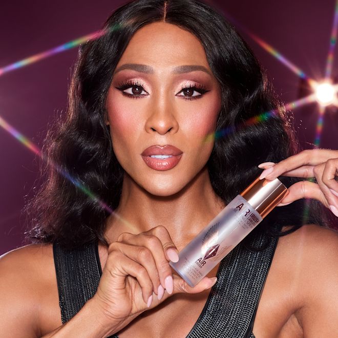 Michaela Jaé Rodriguez holding Airbrush Flawless Setting Spray Michaela Jaé Rodriguez holding Airbrush Flawless Setting Spray