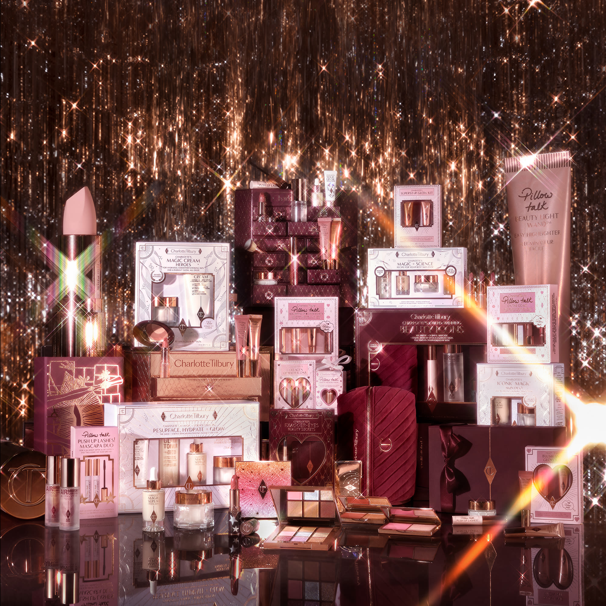 All of Charlotte Tilbury's holiday product collection for 2023 sat next to each other in a sparkly background