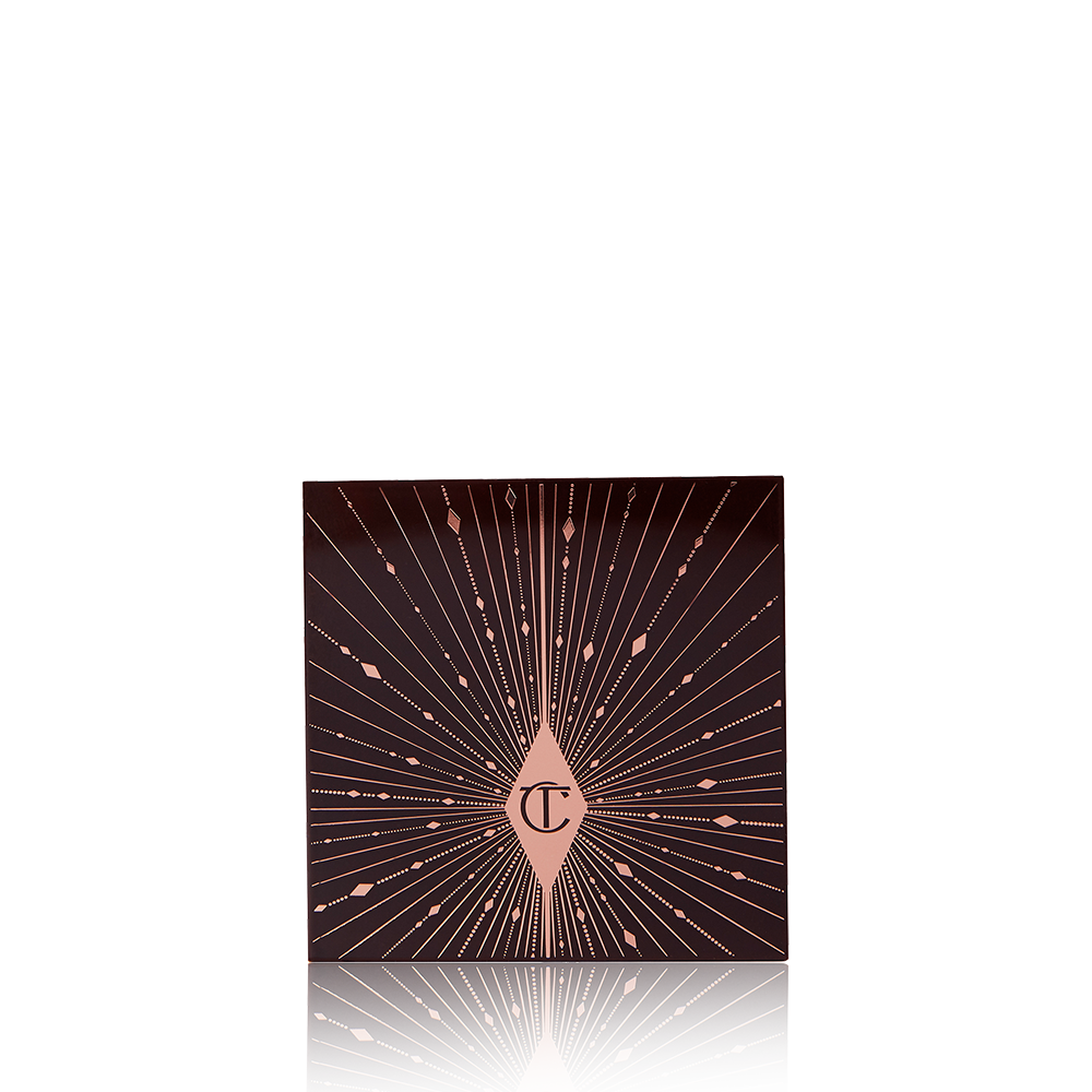 A closed eyeshadow palette with a black-coloured lid with pink-coloured glowy stars printed all over, giving it a starry-night look. 