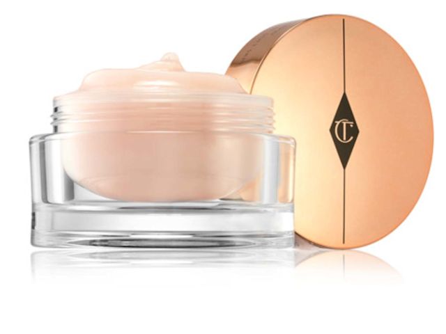 An open, three-in-one, champagne-coloured cleansing balm in a glass jar with a golden-coloured lid. 