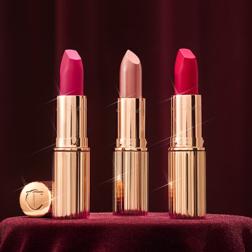 Banner with three open lipsticks, two with a matte finish in magenta and raspberry pink and a satin finish one in a soft rosy peach shade.