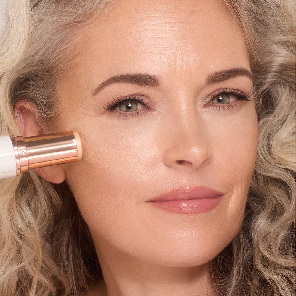 Mature model wearing Unreal Skin Sheer Glow Tint Hydrating Foundation Stick for mature skin