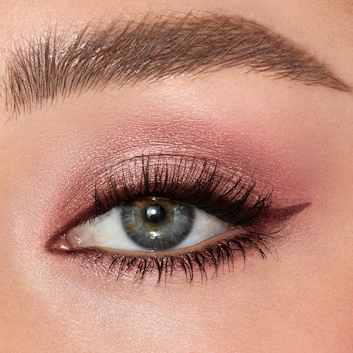 Eyes to mesmerise in Pillow Talk on fair-tone model with blue eyes close-up Single-eye close-up of a fair-tone model with blue eyes wearing shimmery rose gold cream eyeshadow.