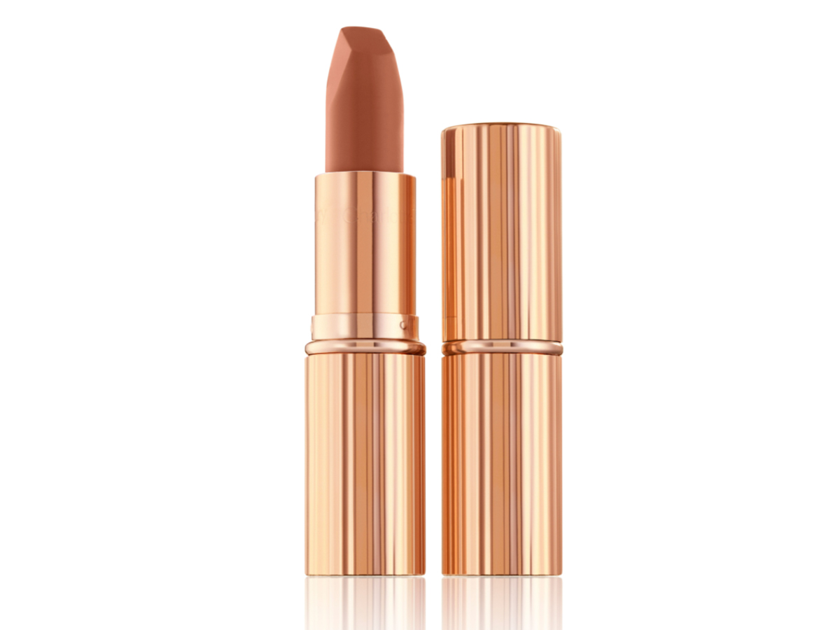 Two lipsticks, with and without lid, in a fresh, neutral nude peach matte shade, in sleek, gold-coloured tubes. 