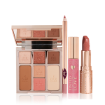 An open face palette with three eyeshadows, two blushes, and contour powders, lip liner pencil in nude pink, lip and cheek tint in a soft pink tube with a gold-coloured lid, and open lipstick in a nude pink shade with a gold-coloured tube. 