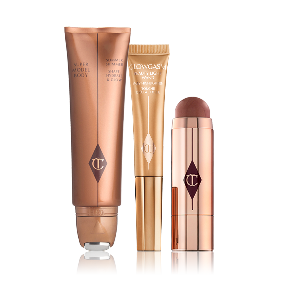 Body highlighter wand in a bronze tube, face highlighter wand in a honey-gold tube, a blush stick in a berry-red shade in gold packaging.