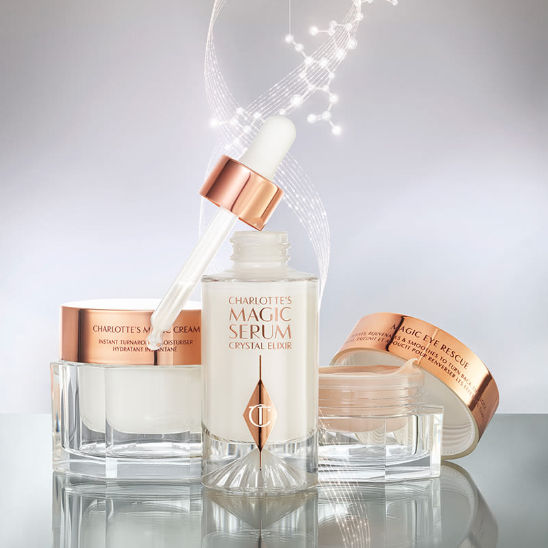 Luminous serum in a glass bottle with a dropper lid, pearly-white face cream in a glass jar with a gold-coloured lid, fawn-coloured eye cream in an open glass jar with a gold-coloured lid.