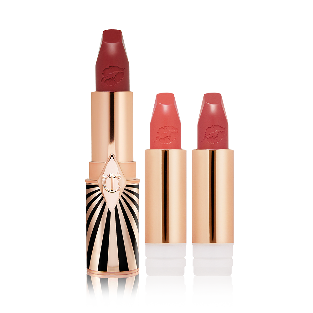 A maroon matte lipstick in a golden and red tube with a black and white print with two lipstick refills in muted red and brownish-peach,