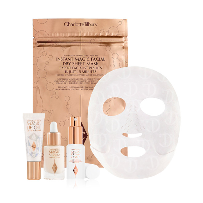 Lip oil in a white-coloured tube, travel-size luminous facial serum in a glass bottle with a dropper lid, travel-size face cream in a white bottle with a pump dispenser, and sheet mask in gold foil packaging.