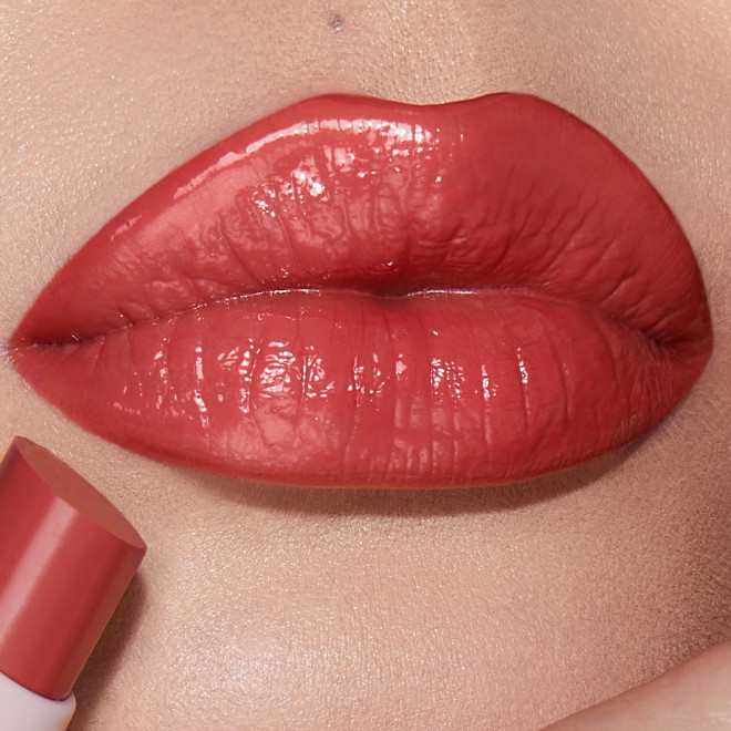 Lips close-up of a light-tone model wearing a moisturising lipstick balm in a peach rose shade.