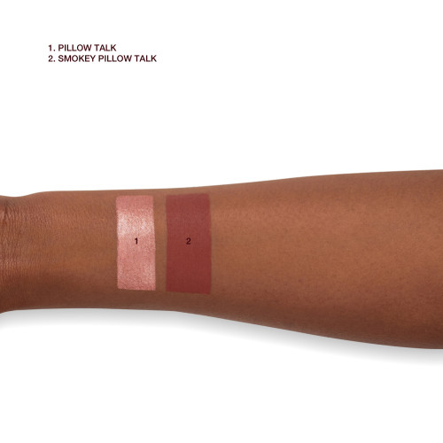 Deep-tone arm with swatches of eyeshadow pencils in rose gold and smokey berry-pink.
