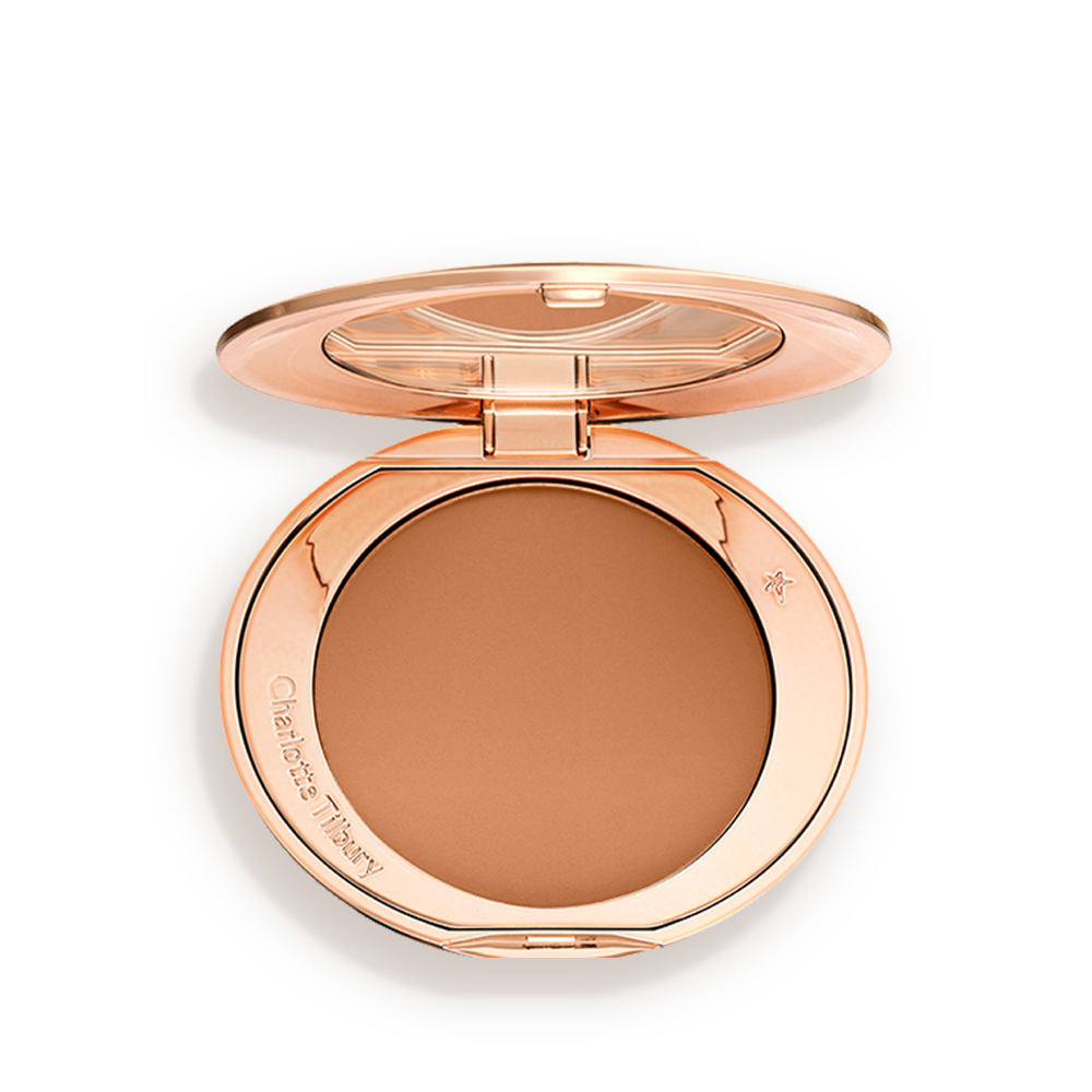 An open, pressed powder compact in a dark brown shade. 