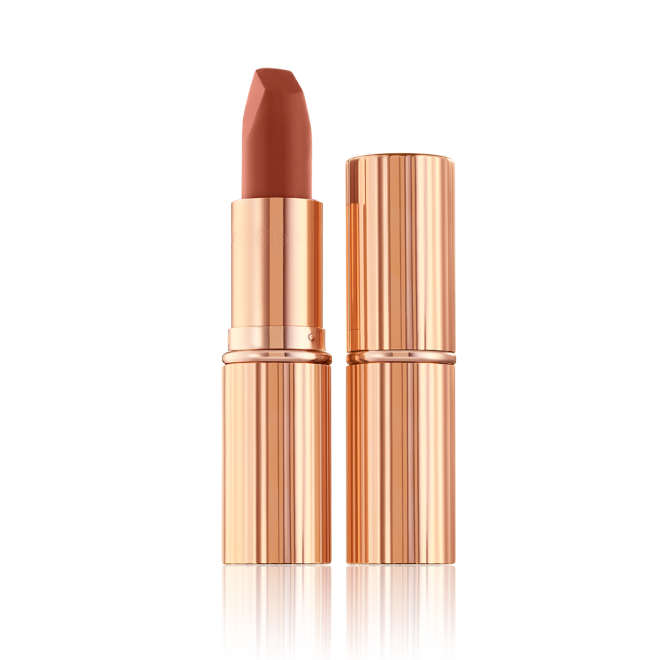 Two lipsticks, with and without lid, in a deep, sultry rose-brown nude matte shade, in sleek, gold-coloured tubes. 