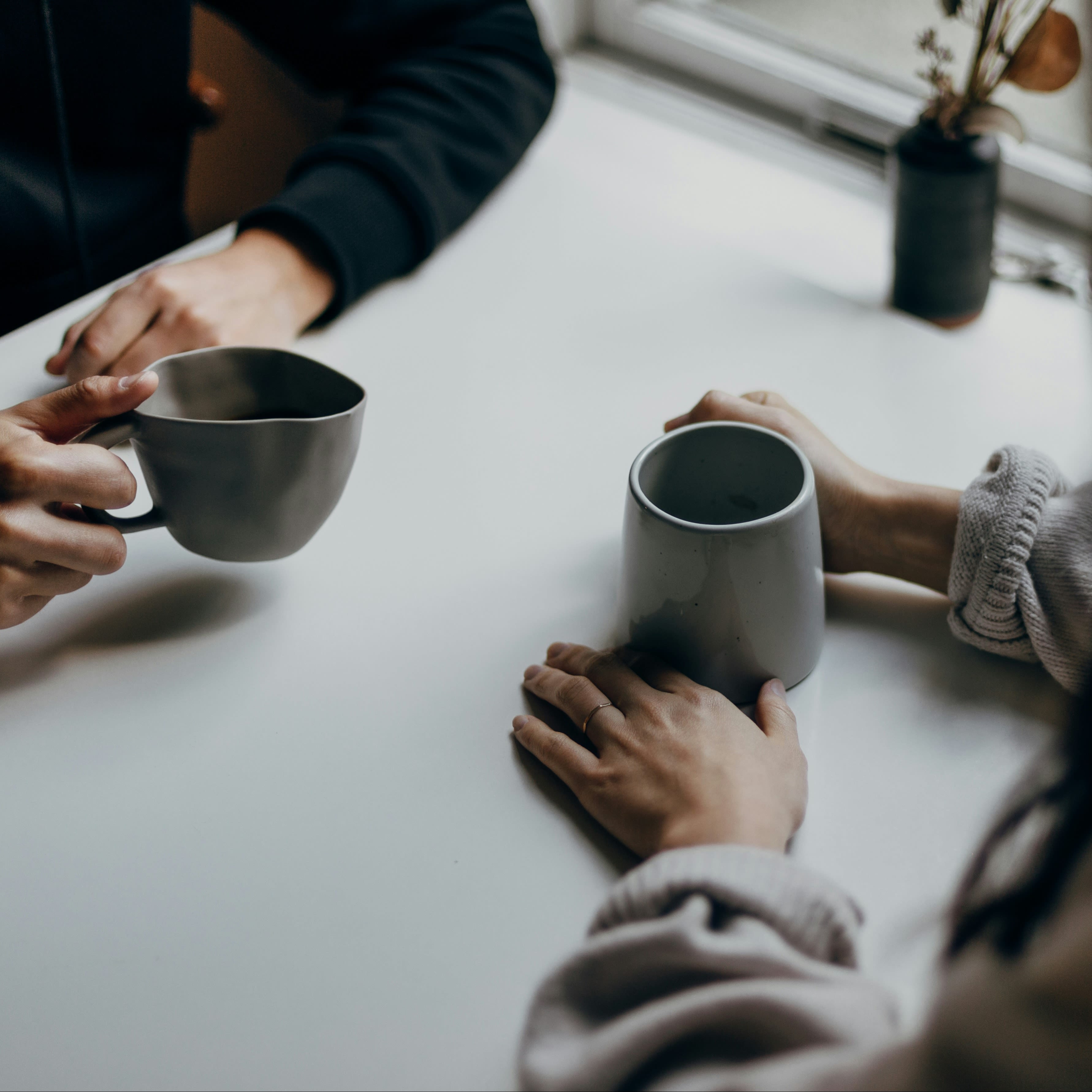 Two people having a conversation over coffee