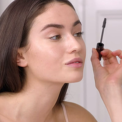 Un mannequin aux cheveux bruns et à la peau claire avec un mascara glowy.