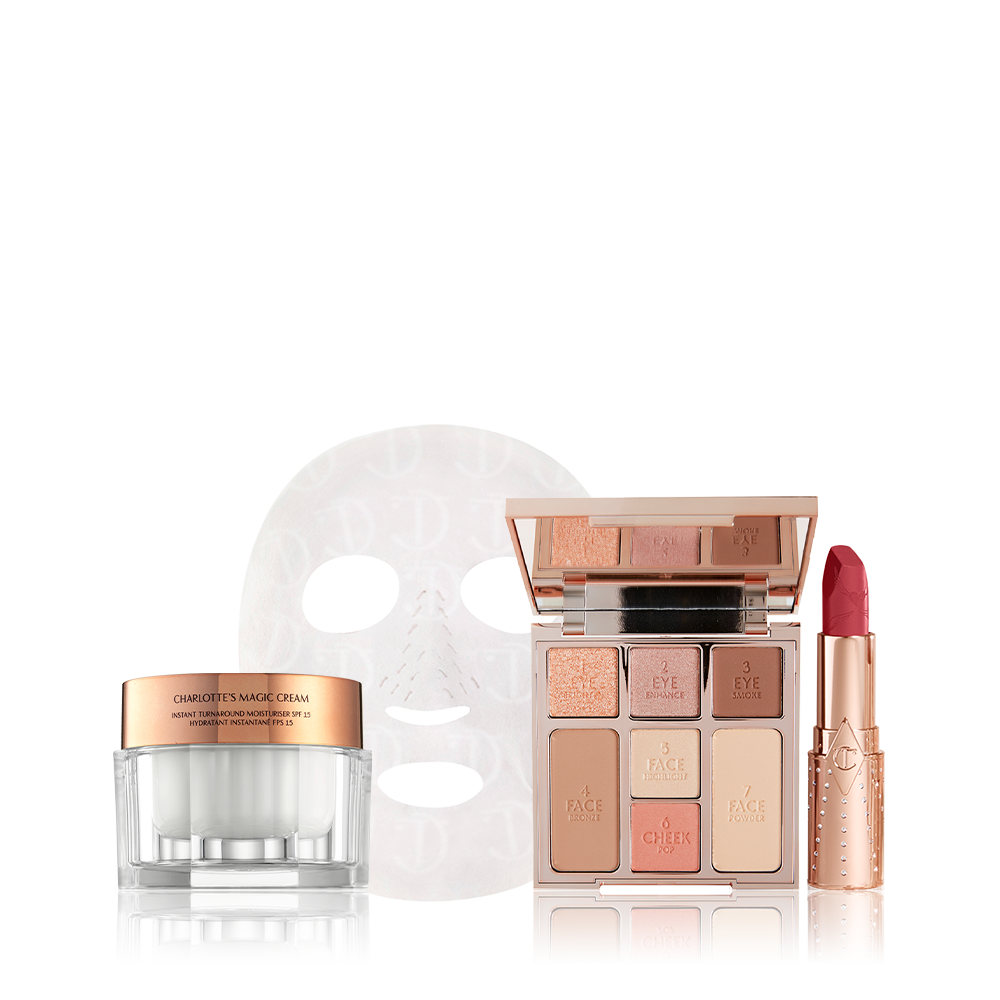 Thick, pearly-white face cream in a glass jar with a gold-coloured lid, textured sheet mask, face palette with three eyeshadows, two blushes, and contour shades, and an open lipstick in a berry-rose shade. 