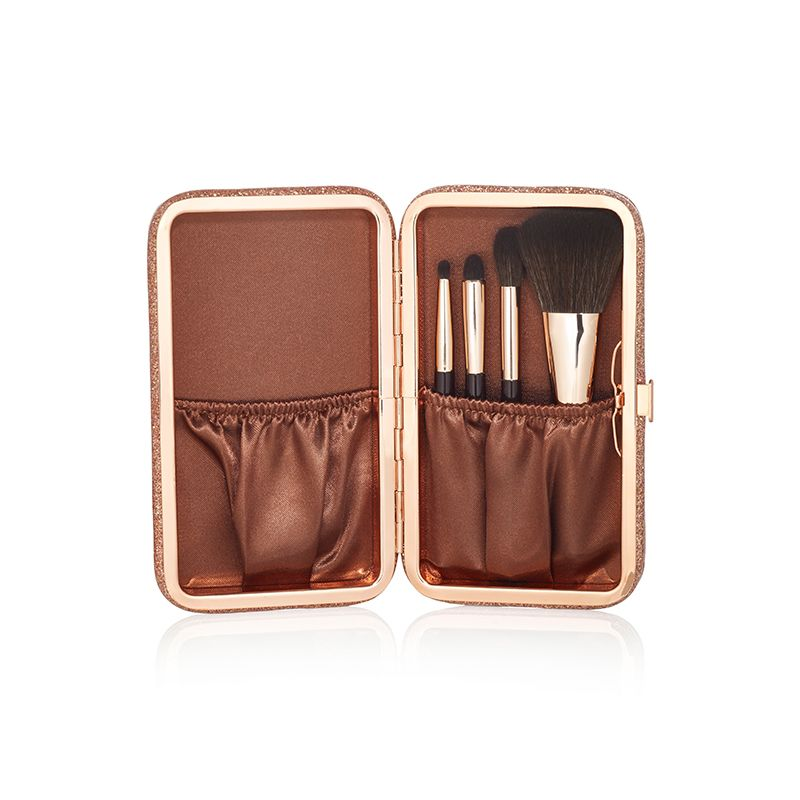 An open makeup clutch brush gift set in brown colour, which includes a foundation brush, powder brush, and two eyeshadow brushes.