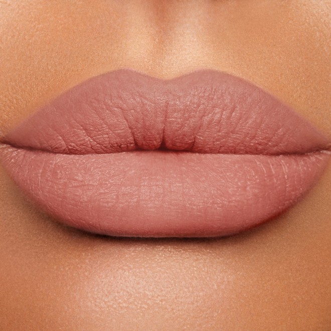 Close-up of a medium-tone model's lips wearing a nude pink lip liner pencil.