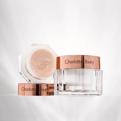 A pearly-white face cream in a large, glass jar with a champagne-coloured eye cream in an open petite glass jar.
