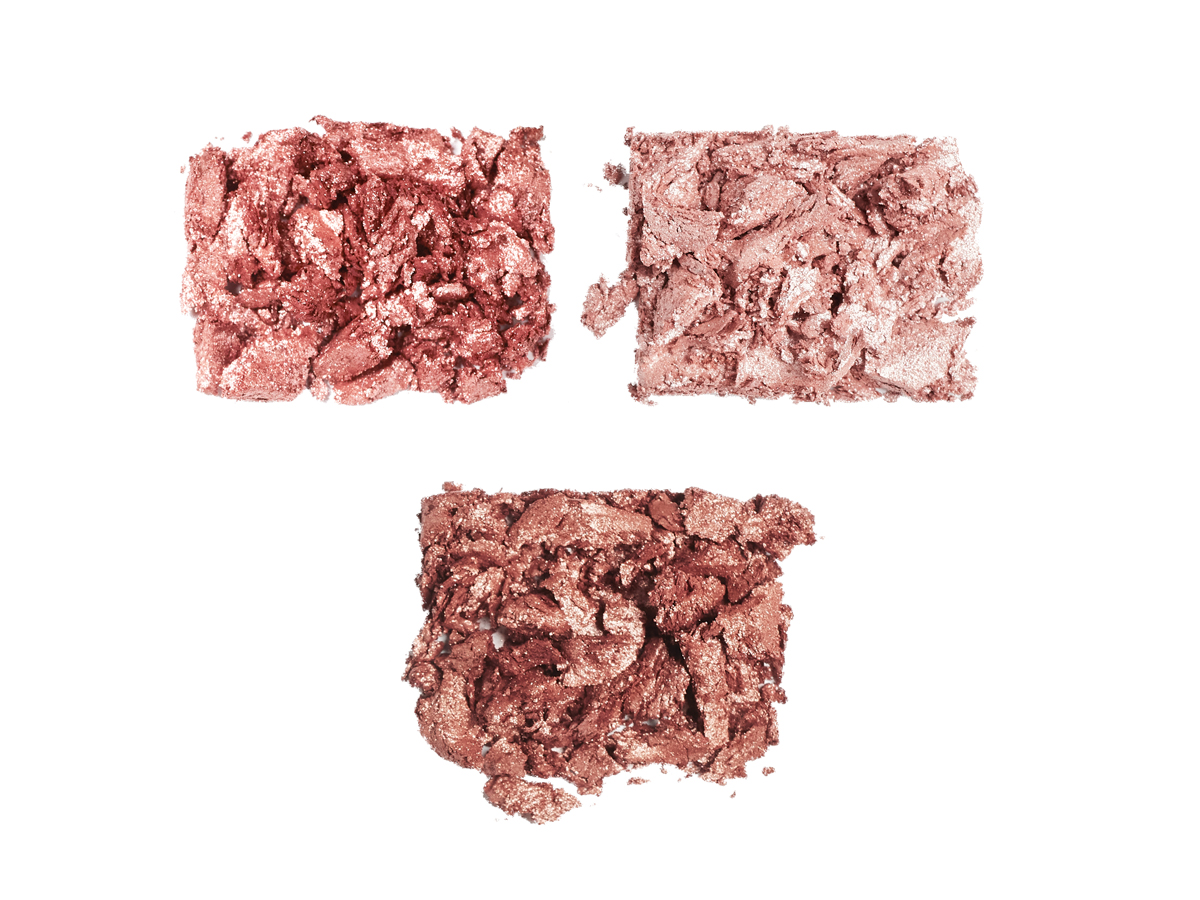 Swatches of three shimmery enhancing eyeshadows in dark rose gold, sheer pink, and coppery-brown.