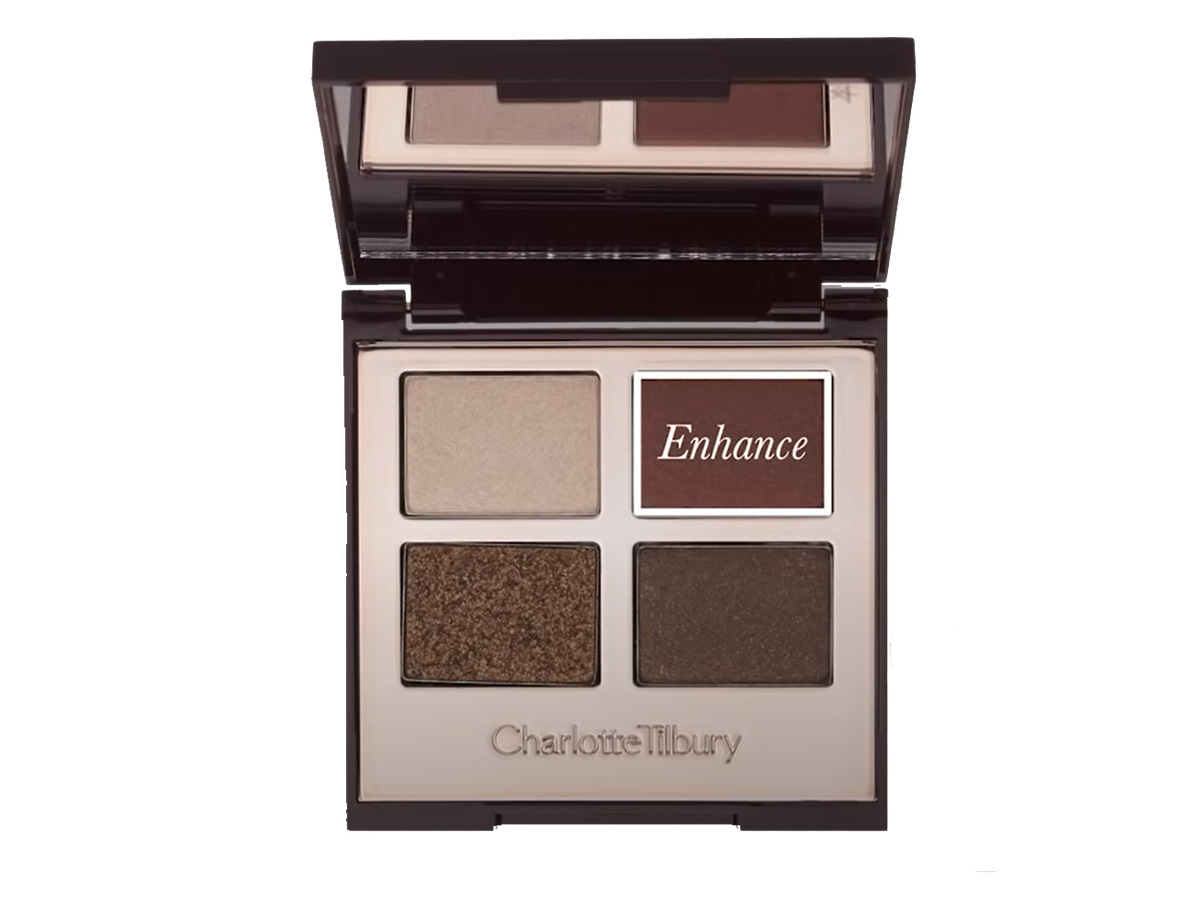 An open, mirrored-lid quad eyeshadow palette with eyeshadows in shades of shimmery brown, dark brown, grey-brown, and dark beige, with enhance written on the dark brown shade. 