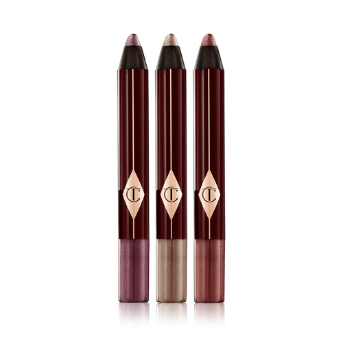 Three, open, chubby eyeshadow sticks in shimmery shades of purple, bronze, and russet rose.