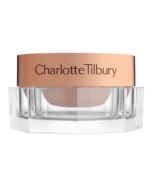 Champagne-coloured eye cream in a petite glass pot with a rose-gold-coloured lid with Charlotte Tilbury written on it. 