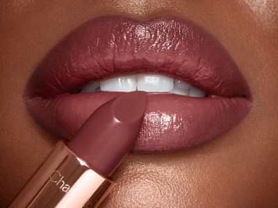 Deep model lip close-up with nude lipstick for dark skin in berry-brown shade with a satin finish. 