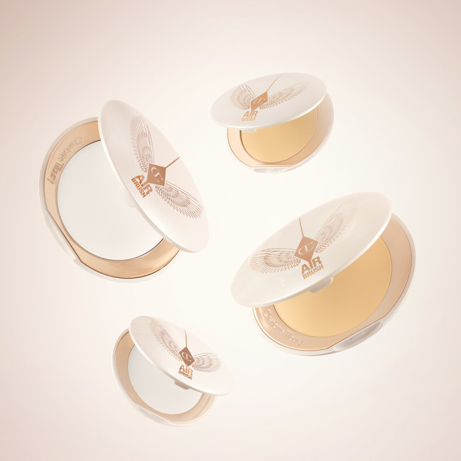A collection of open, setting powder compacts in two shades, fair to light and medium to deep, in white and gold-coloured packaging. 