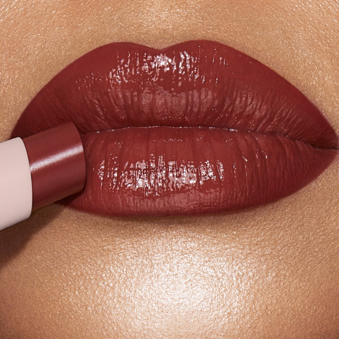 Lips close-up of a light-tone model wearing a peachy nude rose lipstick lip balm. 