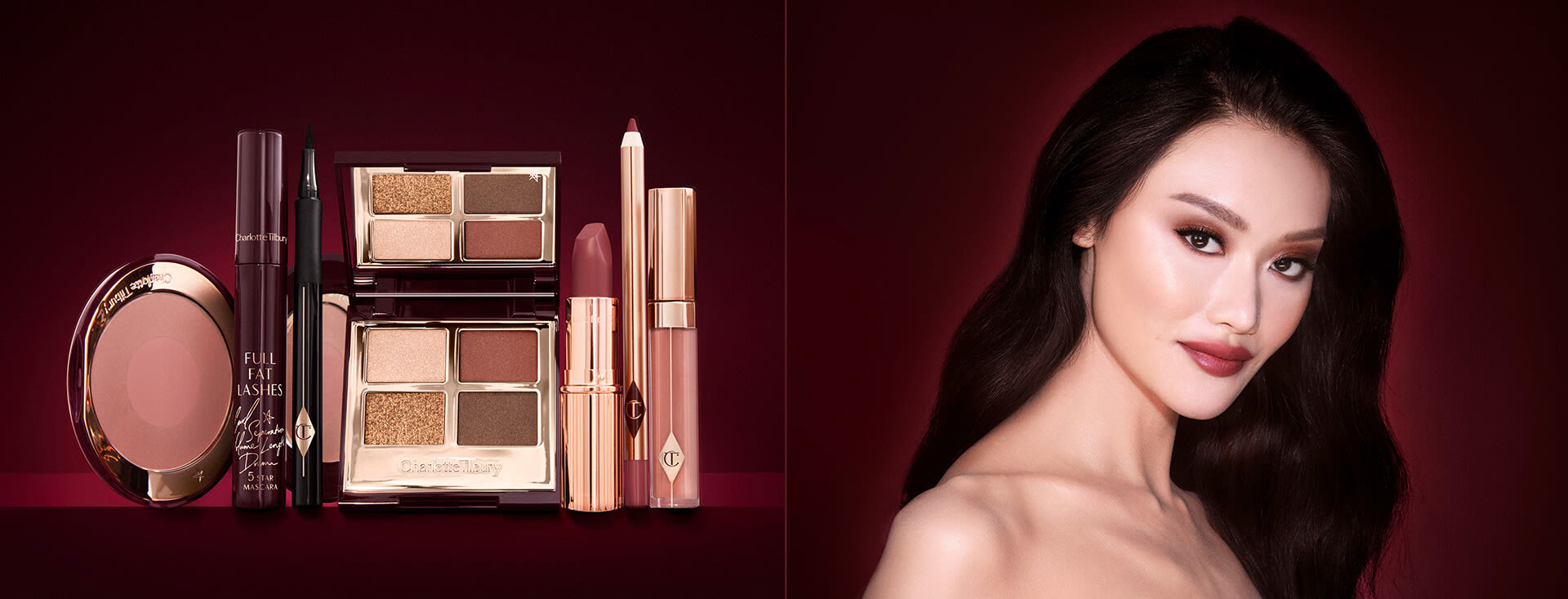 A fair-tone model with brown eyes wearing smokey brown and gold eye makeup with warm pink blush and glossy nude-pink lips next to a makeup kit that includes an open, mirrored-lid eyeshadow palette in matte and shimmery brown and gold shades, an open black eyeliner pen, a mascara in a dark-crimson colour scheme, a berry-rose lipstick with a matching lip liner pencil, nude pink lip gloss, and an open two-tone blush in warm pink. 