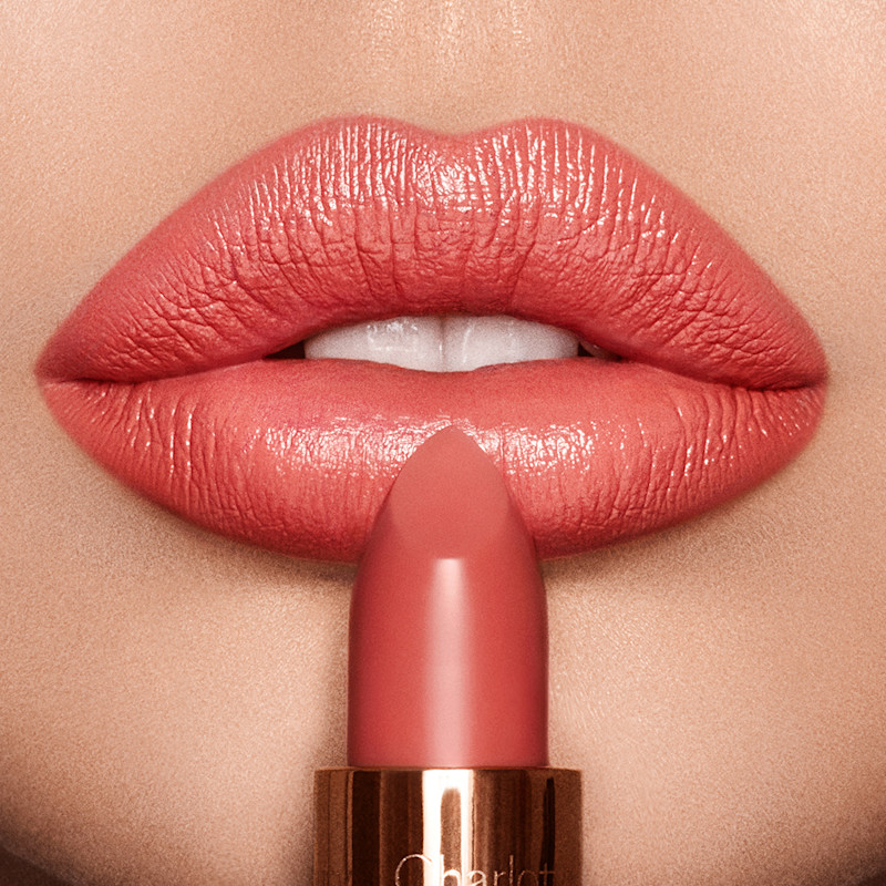 Lip close up of Coral Kiss bright coral lipstick on fair skin