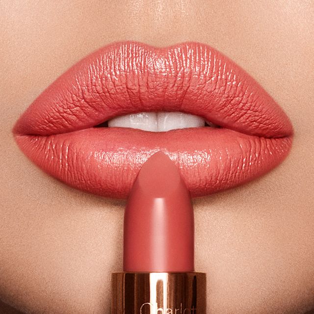Primo piano delle labbra con rossetto corallo acceso Coral Kiss su pelle chiara