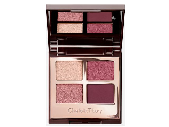 An open, mirrored-lid eyeshadow palette in matte and shimmery purple, pink, and beige shades.