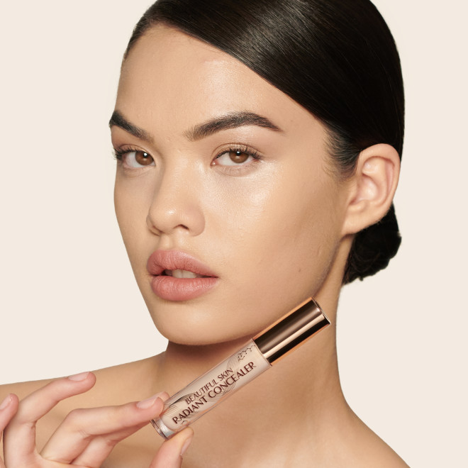 Fair-tone model with brown eyes wearing a radiant, concealer that brightens, covers blemishes, and makes her skin look fresh along with nude lip gloss and subtle eye makeup.