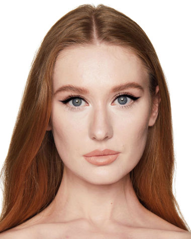 Fair-tone model with blue eyes wearing a nude peach lipstick with a duo eyeliner in black and champagne-beige on her upper lid and lower waterline. 