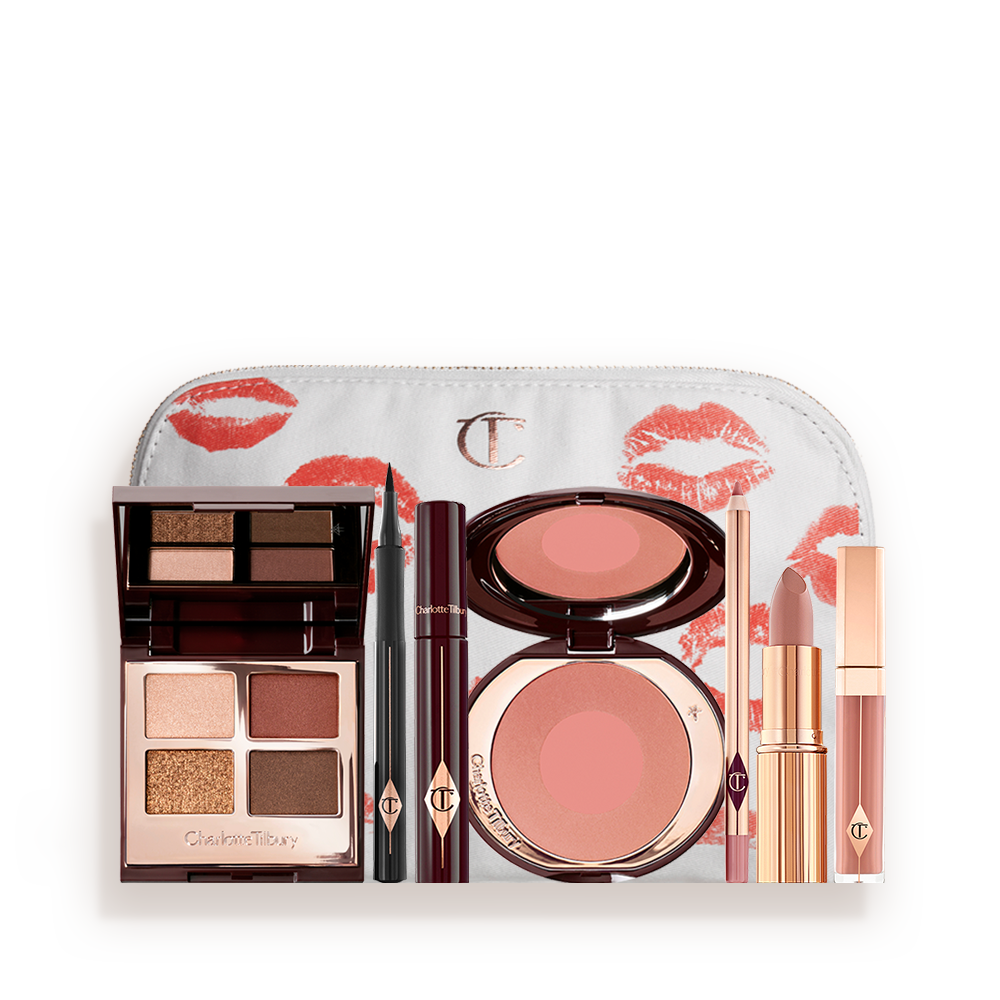 A white makeup pouch with an open, mirrored-lid eyeshadow palette in matte and shimmery brown and gold shades, an open black eyeliner pen, a mascara in a dark-crimson colour scheme, a berry-rose lipstick with a matching lip liner pencil, nude pink lip gloss, and an open two-tone blush in warm pink. 