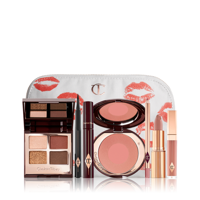 A white makeup pouch with an open, mirrored-lid eyeshadow palette in matte and shimmery brown and gold shades, an open black eyeliner pen, a mascara in a dark-crimson colour scheme, a berry-rose lipstick with a matching lip liner pencil, nude pink lip gloss, and an open two-tone blush in warm pink. 