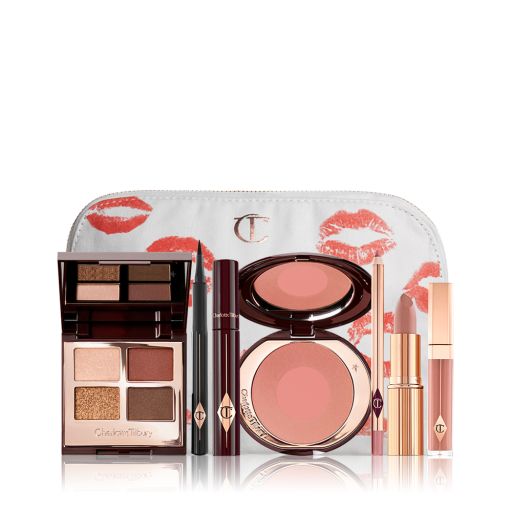 A white makeup pouch with an open, mirrored-lid eyeshadow palette in matte and shimmery brown and gold shades, an open black eyeliner pen, a mascara in a dark-crimson colour scheme, a berry-rose lipstick with a matching lip liner pencil, nude pink lip gloss, and an open two-tone blush in warm pink. 
