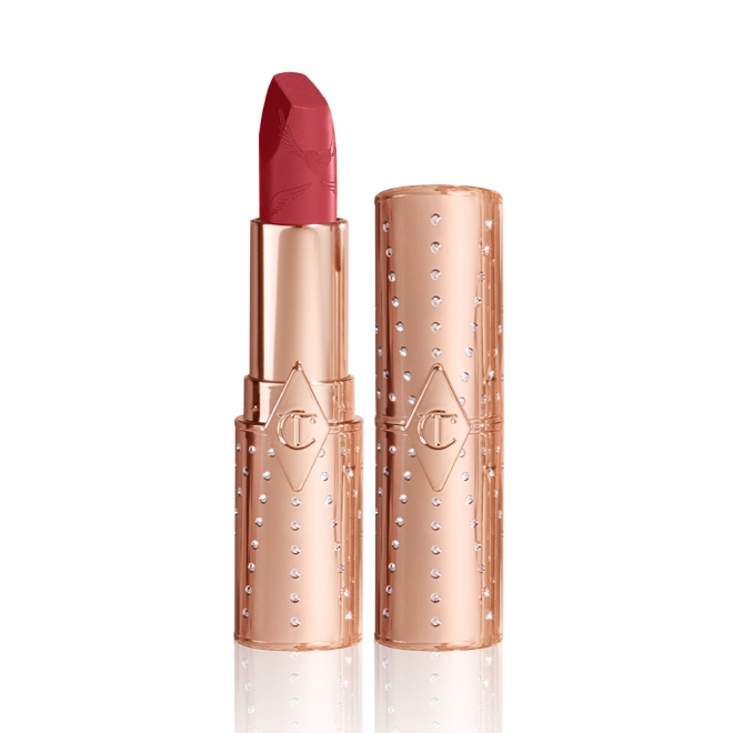 An open, blushed berry-rose lipstick in a metallic, golden-coloured tube with its lid next to it. 