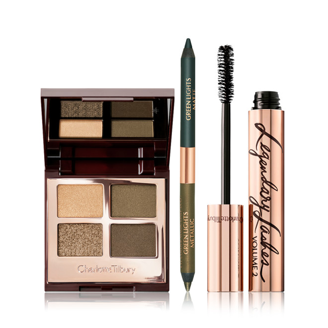 An open, quad eyeshadow palette with eyeshadows in olive-green and golden shades with an open, dual-tip green eyeliner, and mascara in a rose-gold tube with its applicator next to it. 