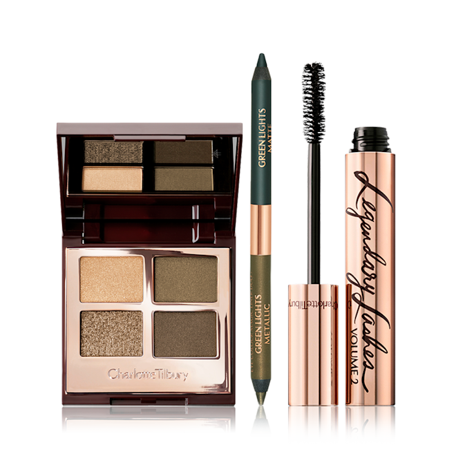 Green lights Magic Trick Kit open An open, quad eyeshadow palette with eyeshadows in olive-green and golden shades with an open, dual-tip green eyeliner, and mascara in a rose-gold tube with its applicator next to it.