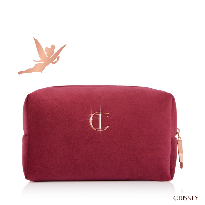 Crimson red velvet makeup bag in sparkling Disney Tinker Bell design with shooting stars and Disney100 X Charlotte Tilbury logo.