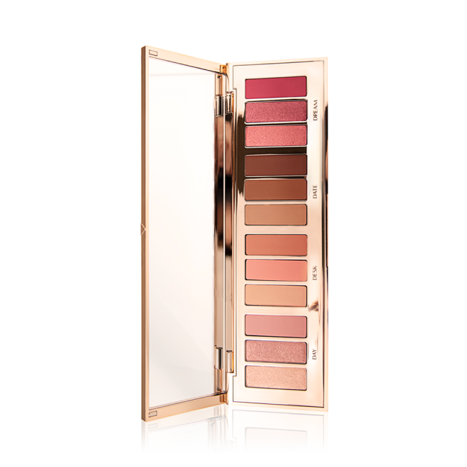 An eye palette with a rose gold, high shine finish with its lid opened, revealing twelve eyeshadows in shades of pink, peach, brown, and champagne. 