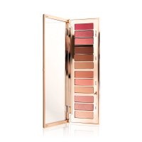 An eye palette with a rose gold, high shine finish with its lid opened, revealing twelve eyeshadows in shades of pink, peach, brown, and champagne. 