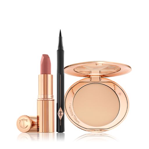 An open nude-pink lipstick in a golden tube with an open black eyeliner pen, and open, mirrored-lid pressed compact in a light shade. 
