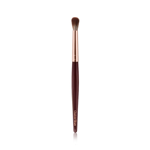 An eyeshadow blending brush with a golden and dark crimson-coloured handle. 